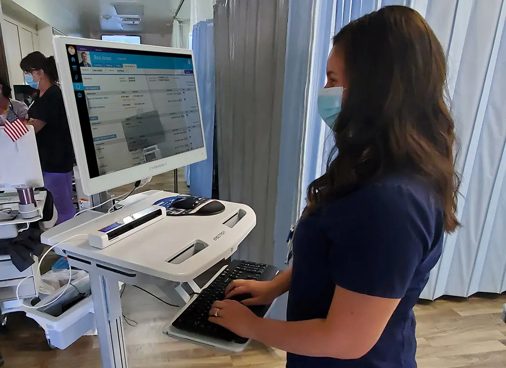 אחות עובדת על עגלה רפואית ממוחשבת עם מחשב CyberMed